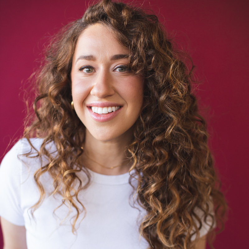 Woman with curly hair, plain shirt. Julia Getz